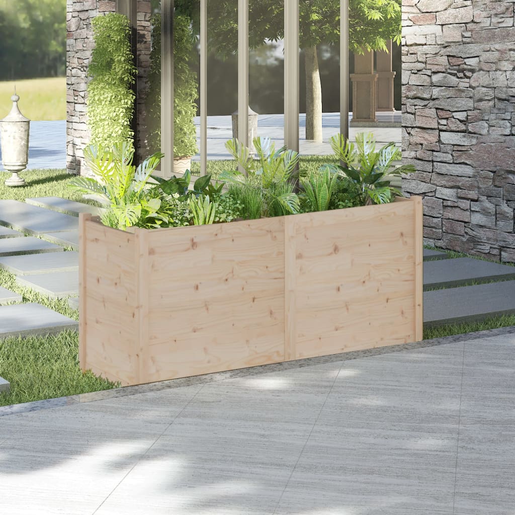 A rectangular solid pine wood garden planter filled with green plants, measuring 59.1x19.7x27.6 inches, placed on a patio near a stone wall.