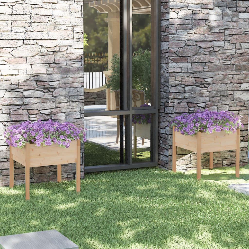 Two 27.6-inch square solid pine wood garden planters with purple flowers, placed against a stone wall.