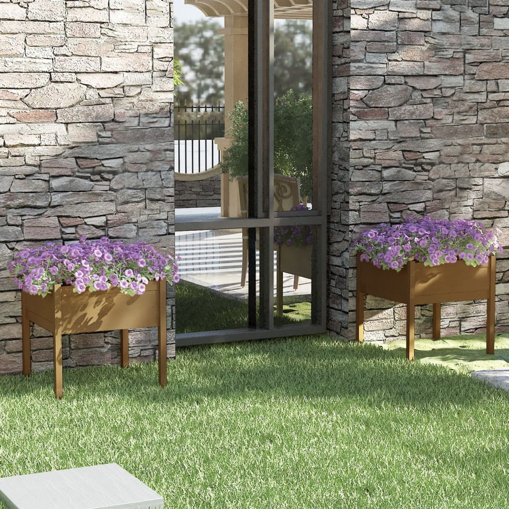 Two honey brown solid pine wood garden planters with purple flowers flank a glass door on a stone wall.