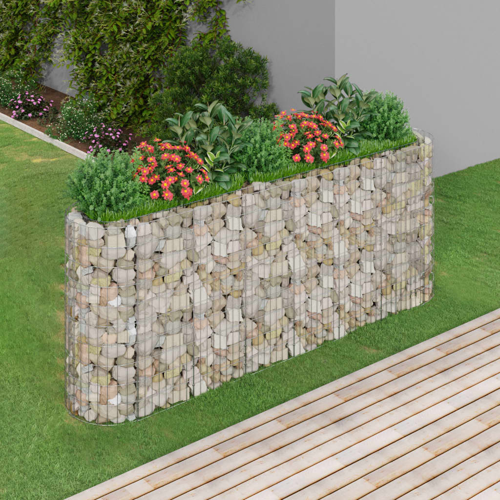 Galvanized iron gabion raised bed measuring 102.4x19.7x39.4 inches, filled with rocks and planted with green shrubs and orange flowers in a garden setting.