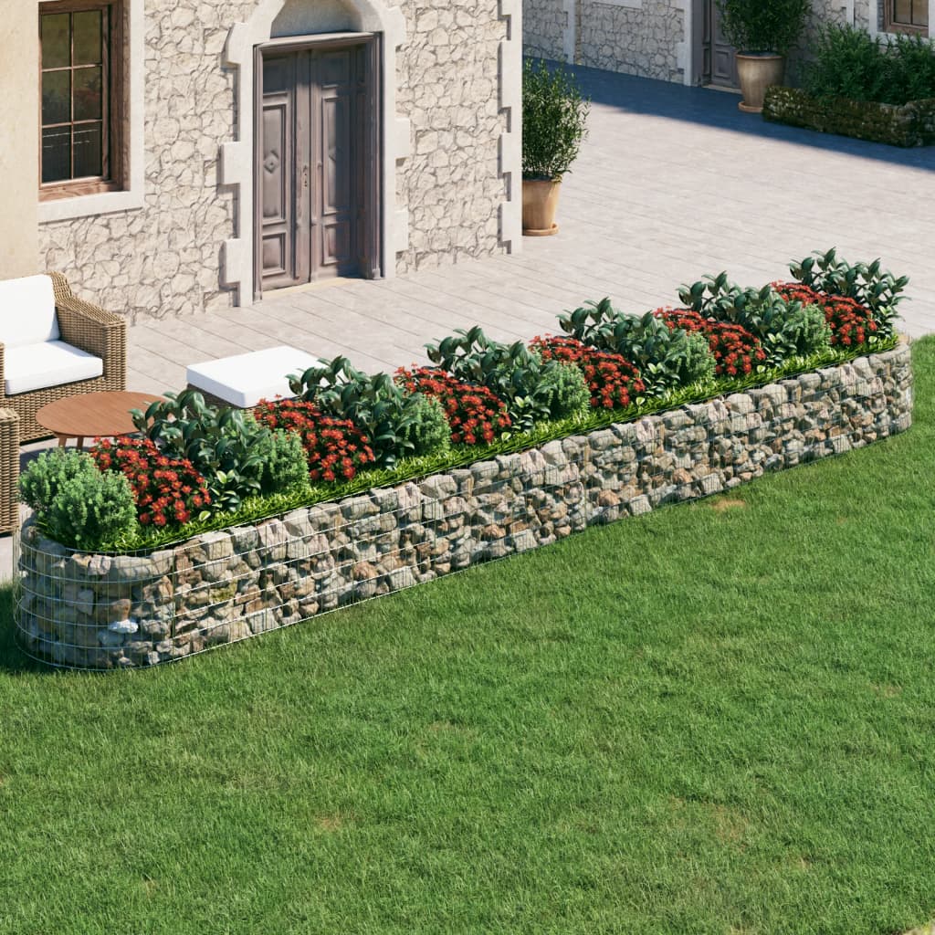 Galvanized iron gabion raised bed with stone walls, red flowers, and outdoor seating.
