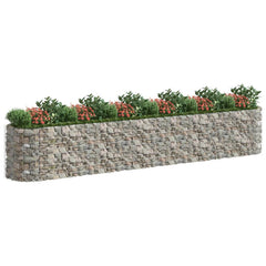 Long galvanized iron gabion raised garden bed with stone-filled wire mesh and plants on top.