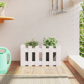 White solid pine garden planter with fence design holding two green plants.