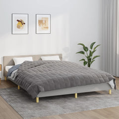 Gray Bostome weighted blanket on a queen bed with white bedding and pillows.