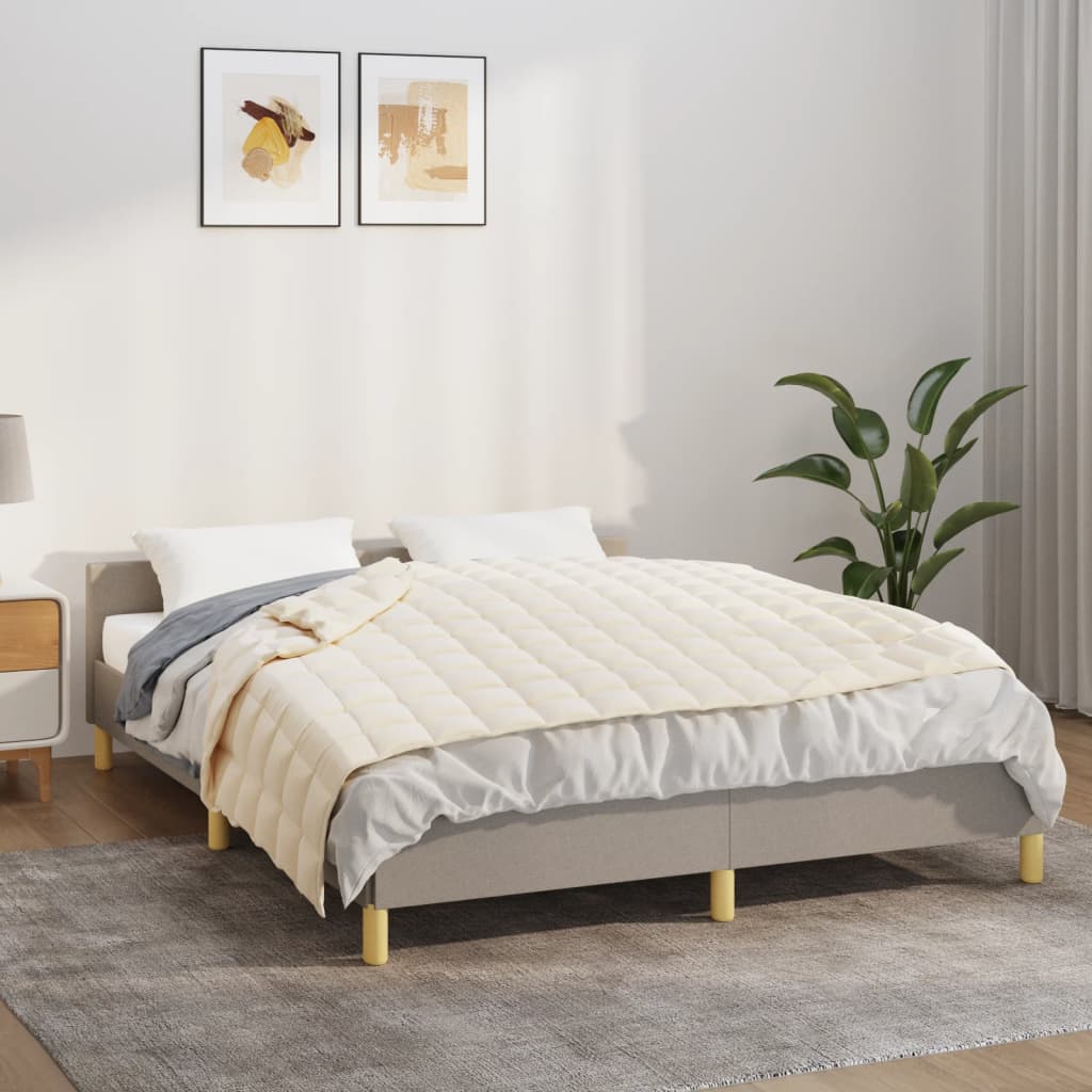 Light cream 22 lb weighted blanket draped over a gray bed frame in a modern bedroom.
