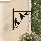 Black powder-coated steel hanging basket bracket with bird design mounted on wall
