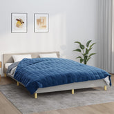 A blue 33.1 lb weighted blanket, 86.6x90.6 inches, on a bed with gray fabric and white pillows.