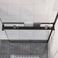 Black aluminum shower shelf with towel bar mounted on glass wall in tiled walk-in shower.