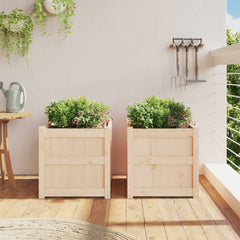 Two square solid pine wood garden planters, 19.7 inches each, with green plants on a balcony.