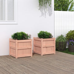 Two square planters made of solid Douglas wood, each filled with green shrubs, placed on a wooden deck.