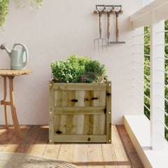 Square wooden garden planter on balcony with plants, watering can, and tools.