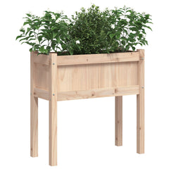 Wooden elevated garden planter with legs, filled with green plants.