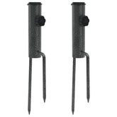 Two galvanized steel parasol stands with spikes for stability in outdoor settings.
