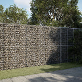 Galvanized iron gabion basket wall filled with stones in a garden setting.
