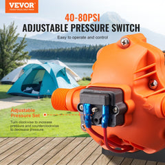 Orange 12V diaphragm water pump with 40-80 PSI adjustable pressure switch, shown outdoors near tents and lake.