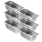 Six 1/3-size stainless steel steam table pans, 4 inches deep, stacked neatly.