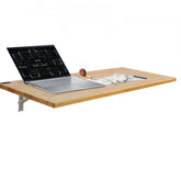 A 47.24-inch rubberwood wall-mounted folding table with a silver laptop, measuring tape, and papers on its surface.