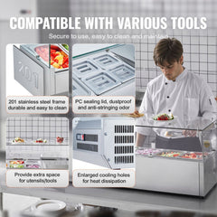 Stainless steel refrigerated condiment prep station with glass guard and pan inserts.