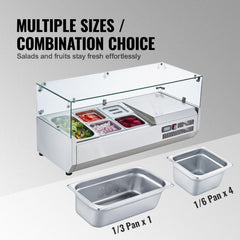 Countertop refrigerated condiment prep station with glass guard and stainless steel pans.
