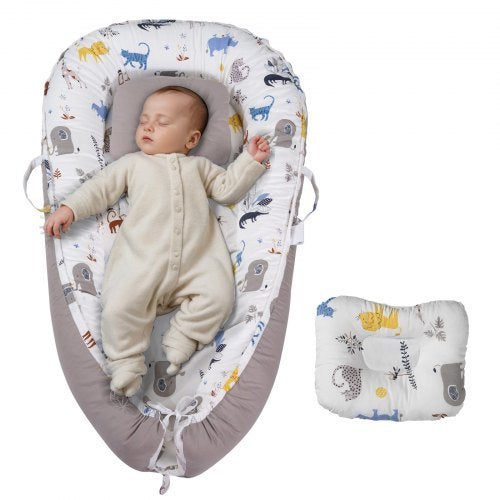 A white 100% cotton baby lounger with animal prints cradles a sleeping newborn, including a matching headrest pillow.