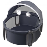 Portable baby bassinet with a folding design, canopy, and two developmental toys.