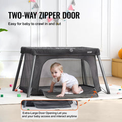 Dark gray folding baby travel crib play yard with a zipper gate and breathable mesh sides.