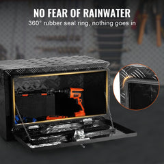 Black aluminum underbody truck tool box, 30x14x16 inches, open with orange drill inside, featuring 360-degree rubber seal.