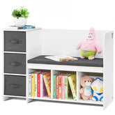 White kids reading nook bench with gray drawers, open shelves holding books and toys, and a gray cushion seat.
