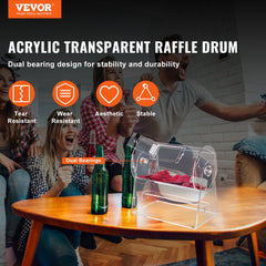 Transparent acrylic raffle drum with spinning cage holding tickets on a wooden table.