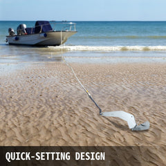 A 14lb stainless steel delta boat anchor with quick-setting design buried in sand near a boat on the beach.