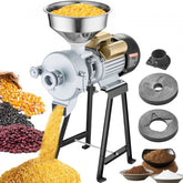 Electric grain grinder with stainless hopper, motor, and stand, grinding corn and beans.