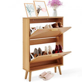 Wooden shoe cabinet with two rattan flip drawers and angled legs holding multiple pairs of shoes.