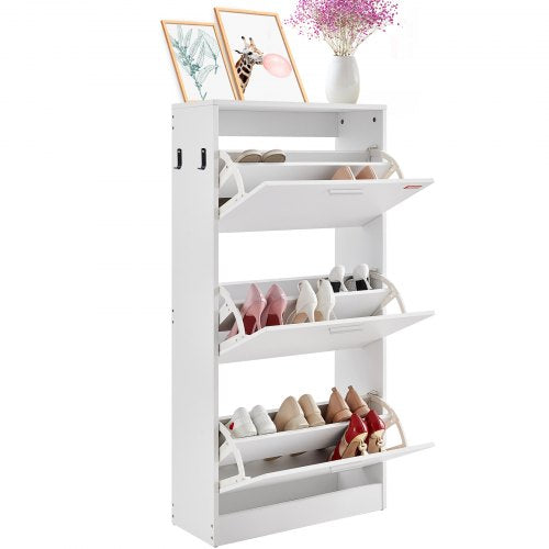 White shoe cabinet with three flip drawers, storing various shoes, beside flowers.