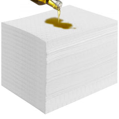 A stack of white oil absorbent pads with oil being poured onto the top pad.