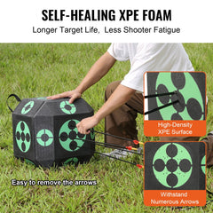 A black 15x15-inch portable archery target cube made of self-healing XPE foam, shown with arrows inserted and a man pulling them out on grass.