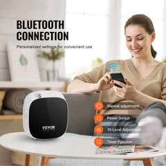 White Bostome scent diffuser on table with woman using Bluetooth app, showing manual controls.