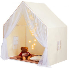 Beige yurt-style kids play tent with sheer curtains, pillow, teddy bear, and hanging lights inside.