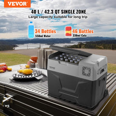 A gray 40L single-zone portable compressor car refrigerator freezer with open lid, holding bottles, placed on a picnic table outdoors.