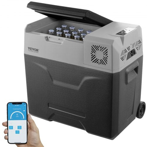 A gray Bostome 50L portable compressor refrigerator with open lid showing bottled drinks inside, wheels, and a hand holding a smartphone app.