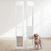 White adjustable dog door installed in sliding glass panels, with a Labrador standing beside the open flap.