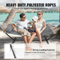 A two-person hammock with a 12ft steel stand, shown with a family lounging on a beach.