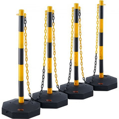 Four yellow and black adjustable traffic delineator posts with chains and weighted bases.