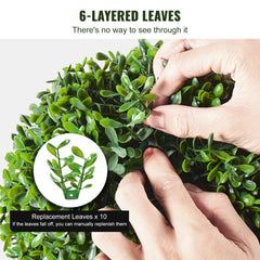 Close-up of hands adjusting dense 6-layer artificial boxwood leaves on a 3ft topiary tree.