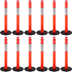 Twelve orange and silver traffic delineator posts with black rubber bases are arranged in rows.
