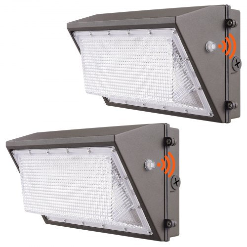 Two gray 100W LED wall pack lights with white diffusers, motion sensors, and dusk-to-dawn photocells.