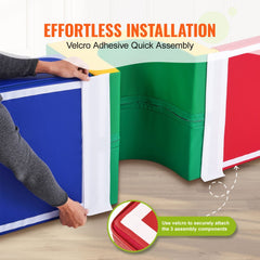 Person assembling a 3-piece toddler foam playset with blue, green, and red tunnel, ramp, and stairs using Velcro strips.