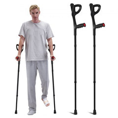 A man uses black forearm crutches with red accents, while two identical crutches stand beside him.