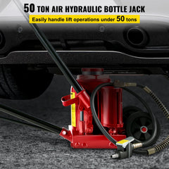 Red 50-ton air hydraulic bottle jack with black handle, hose, and wheels on a gray surface.