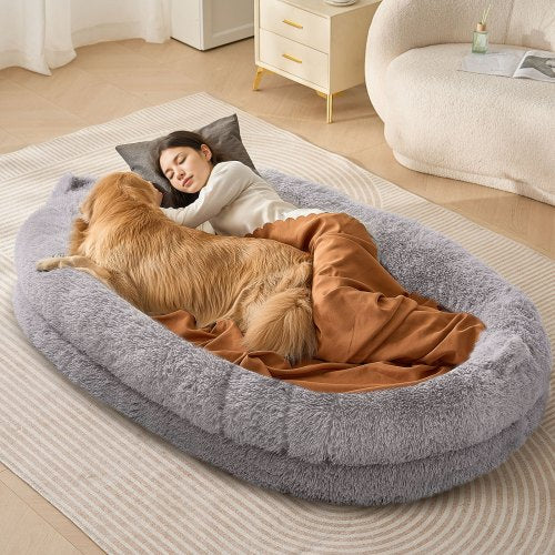 A gray PV velvet human-sized dog bed with a woman and golden retriever lounging inside.