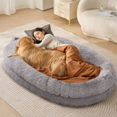 A gray PV velvet human-sized dog bed with a woman and golden retriever lounging inside.